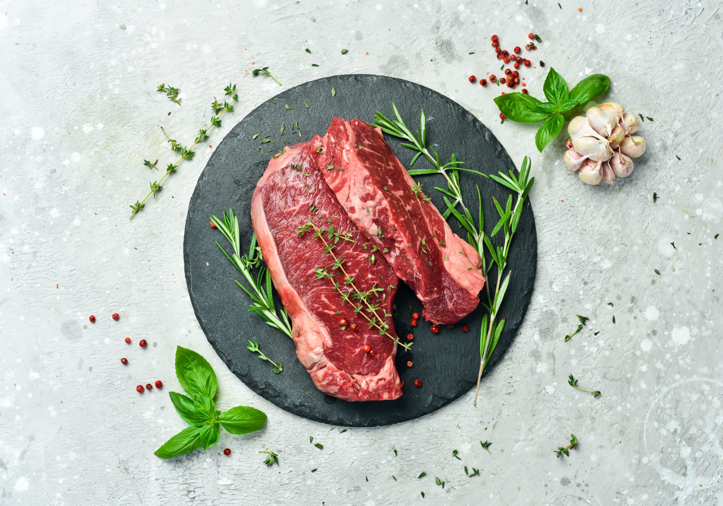 Meat Aged striploin steak On a gray concrete background Free space for text